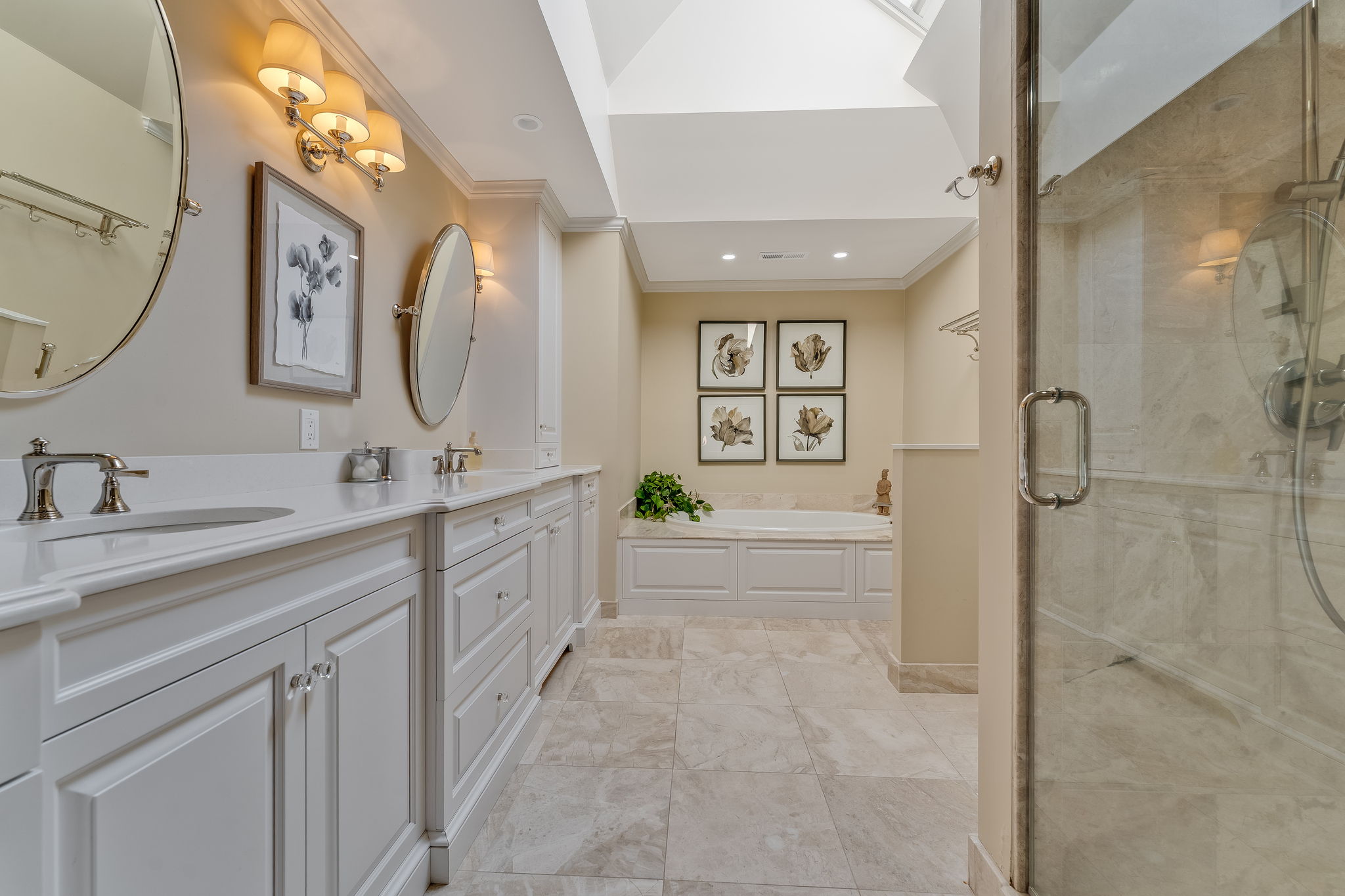 PRIMARY BATH Remodeled 2016, Pocket Door Entry, Volume Ceiling, Skylight with Remote Controlled Shade, Ceiling Heat Fan, Recessed Lighting. 2 Tilting Oval Wall Mirrors, Custom White Vanity, Dual Laundry Hampers, Quartz Countertop, Undermount Porcelain Sinks