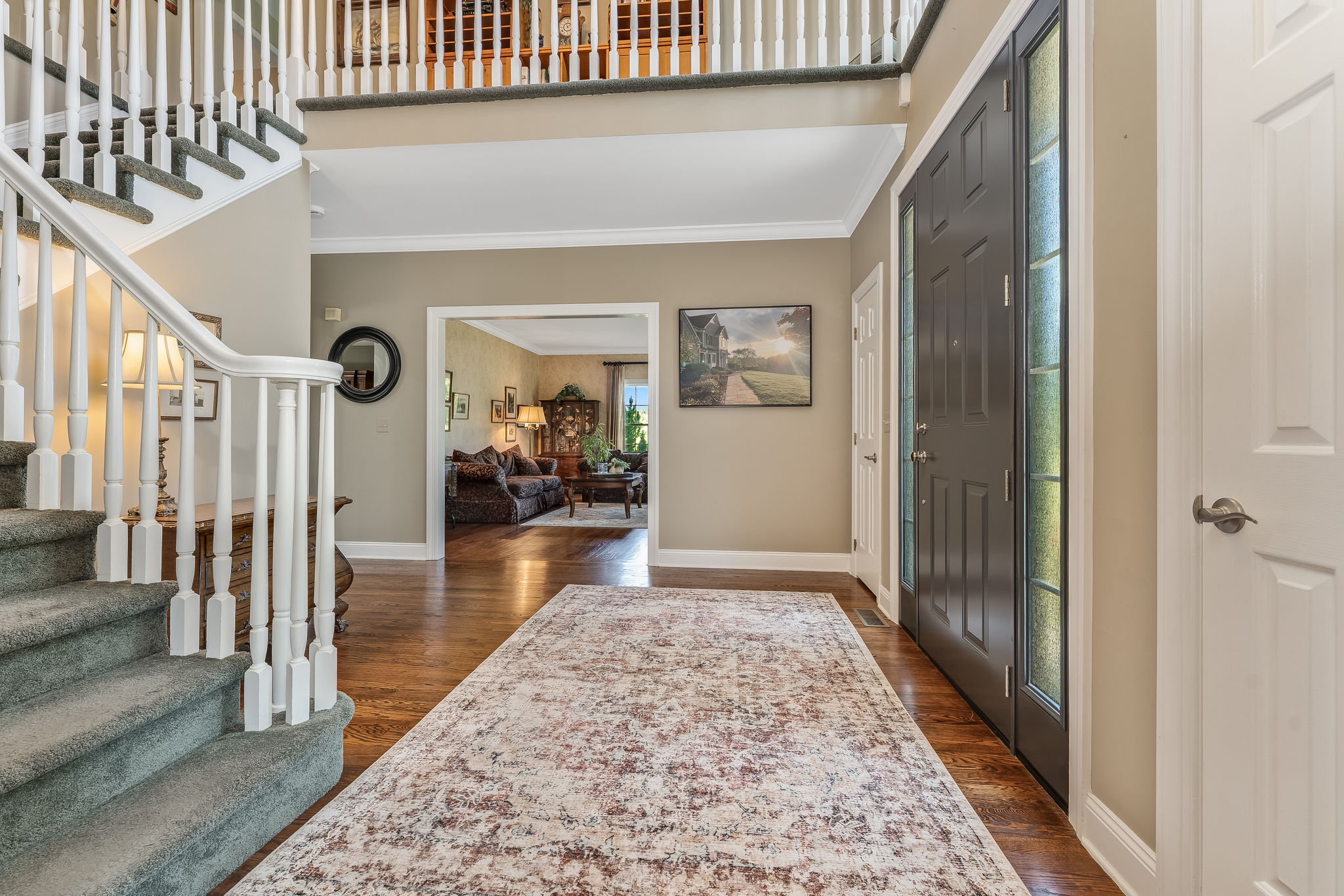 TWO STORY FOYER Andersen Entry Door with Sidelights, Crown Moulding, 2 Tier Candle Chandelier, Sentry Closets, Hardwood Flooring