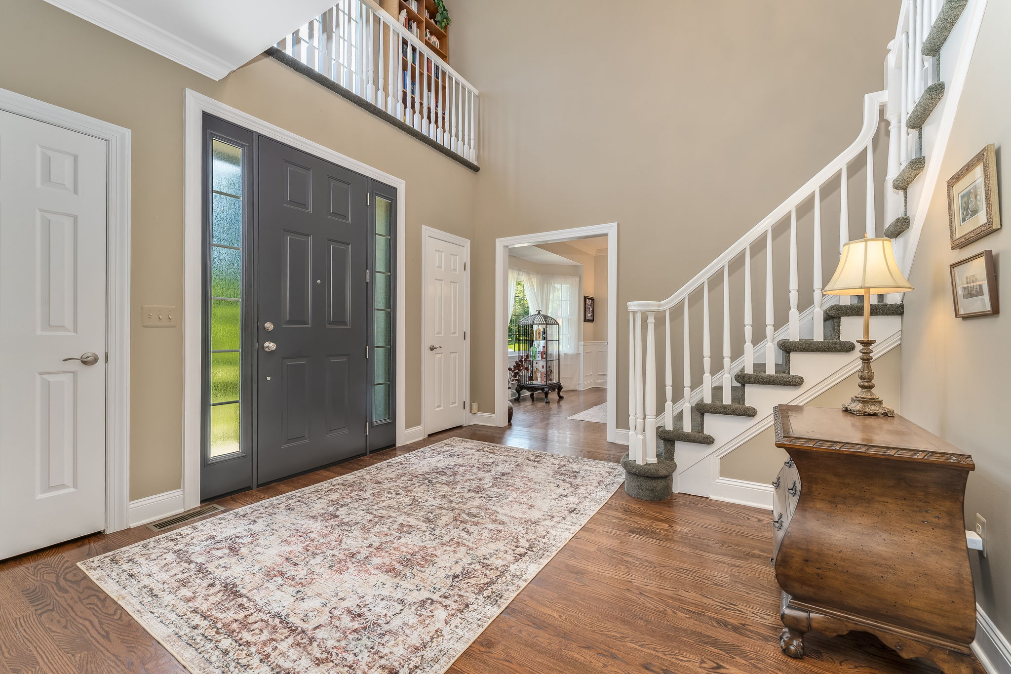 TWO STORY FOYER Andersen Entry Door with Sidelights, Crown Moulding, 2 Tier Candle Chandelier, Sentry Closets, Hardwood Flooring