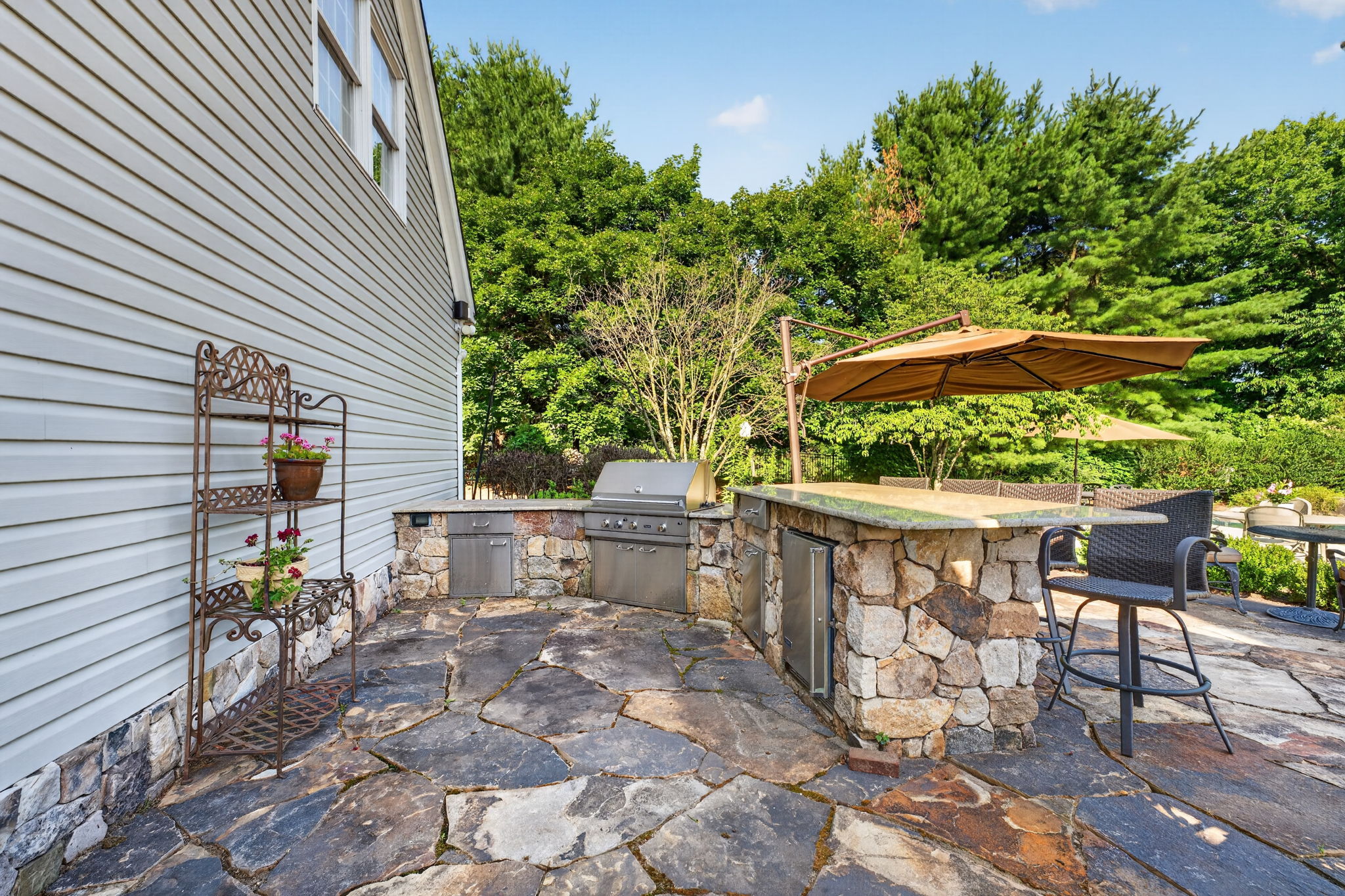OUTDOOR KITCHEN The custom outdoor kitchen provides an extraordinary space for al fresco dining and gatherings. Professional 5 Series Grill with Rotisserie and TruSear Infrared Burner, Grill Storage, Granite Countertop, Refrigerator, Trash Receptacle