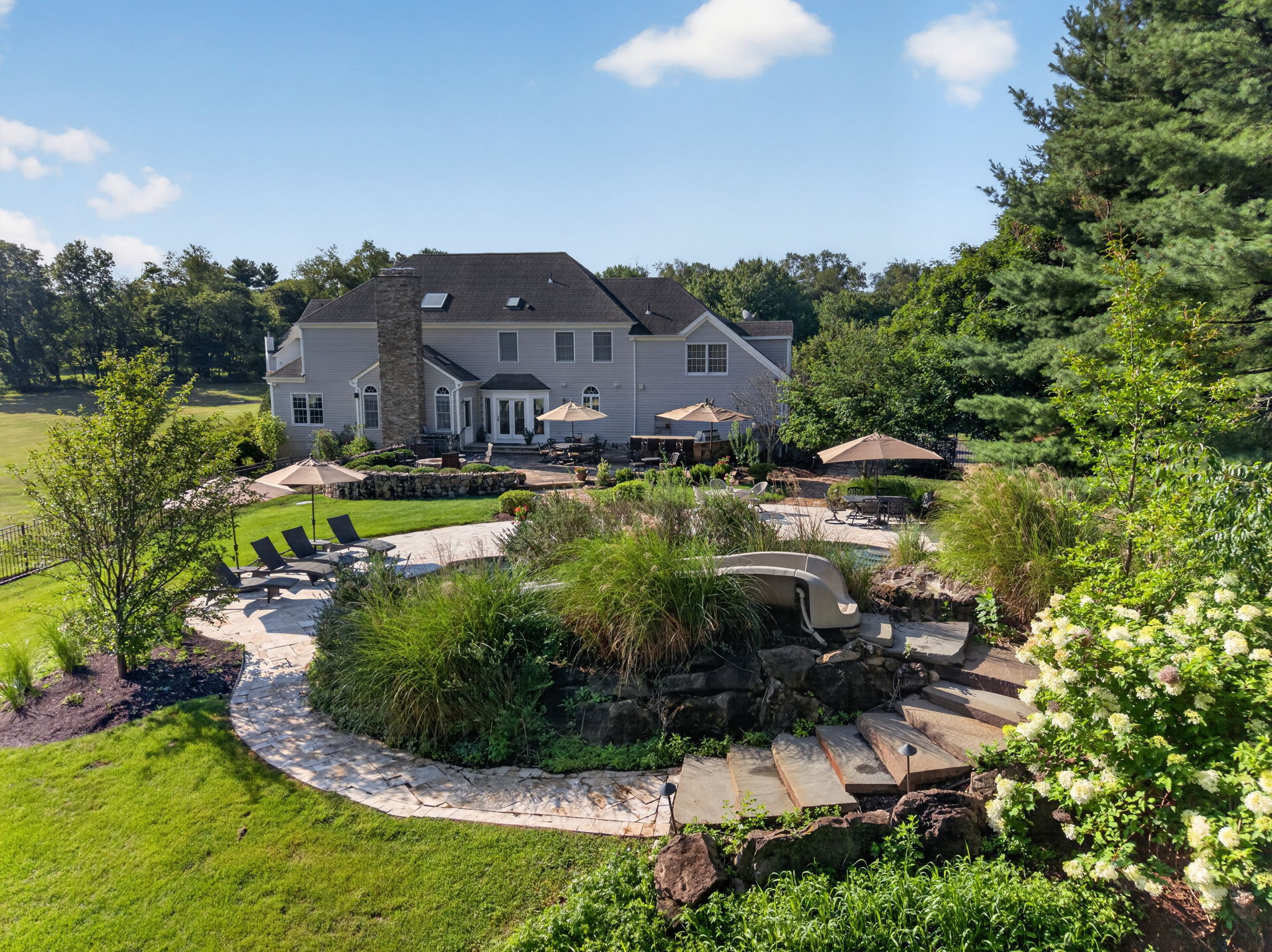 SALTWATER POOL Custom Heated Saltwater Pool with Travertine Coping And Patio Surround/Natural Stone Waterfall/Custom Slide/Pennsylvania Moss Rock Diving Stone. Polaris Aqua Plus Robotic Pool Cleaner (included).