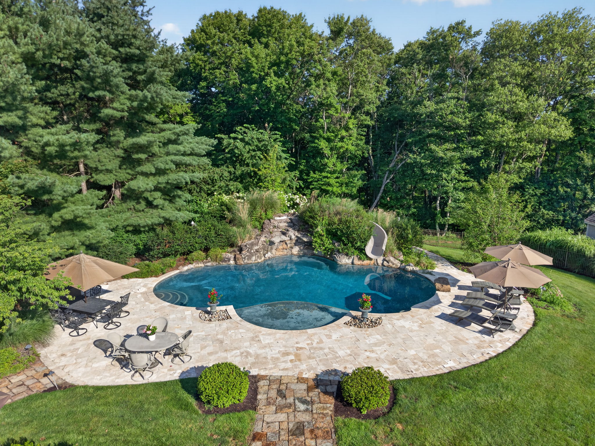 PATIO/POOL Completing the private backyard oasis is a heated saltwater pool with a custom pool slide, offering the ultimate resort-style experience right at home.
