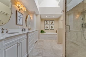 PRIMARY BATH Remodeled 2016, Pocket Door Entry, Volume Ceiling, Skylight with Remote Controlled Shade, Ceiling Heat Fan, Recessed Lighting. 2 Tilting Oval Wall Mirrors, Custom White Vanity, Dual Laundry Hampers, Quartz Countertop, Undermount Porcelain Sinks