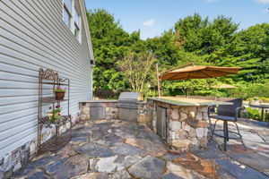 OUTDOOR KITCHEN The custom outdoor kitchen provides an extraordinary space for al fresco dining and gatherings. Professional 5 Series Grill with Rotisserie and TruSear Infrared Burner, Grill Storage, Granite Countertop, Refrigerator, Trash Receptacle