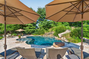 SALTWATER POOL Custom Heated Saltwater Pool with Travertine Coping And Patio Surround/Natural Stone Waterfall/Custom Slide/Pennsylvania Moss Rock Diving Stone. Polaris Aqua Plus Robotic Pool Cleaner (included).