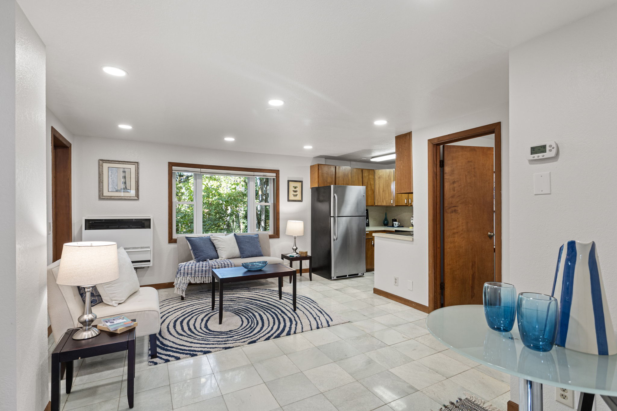 Tile floors and big windows give this lower-level living space a bright, grounded feel. East-facing exposure brings in peaceful morning light through the trees.