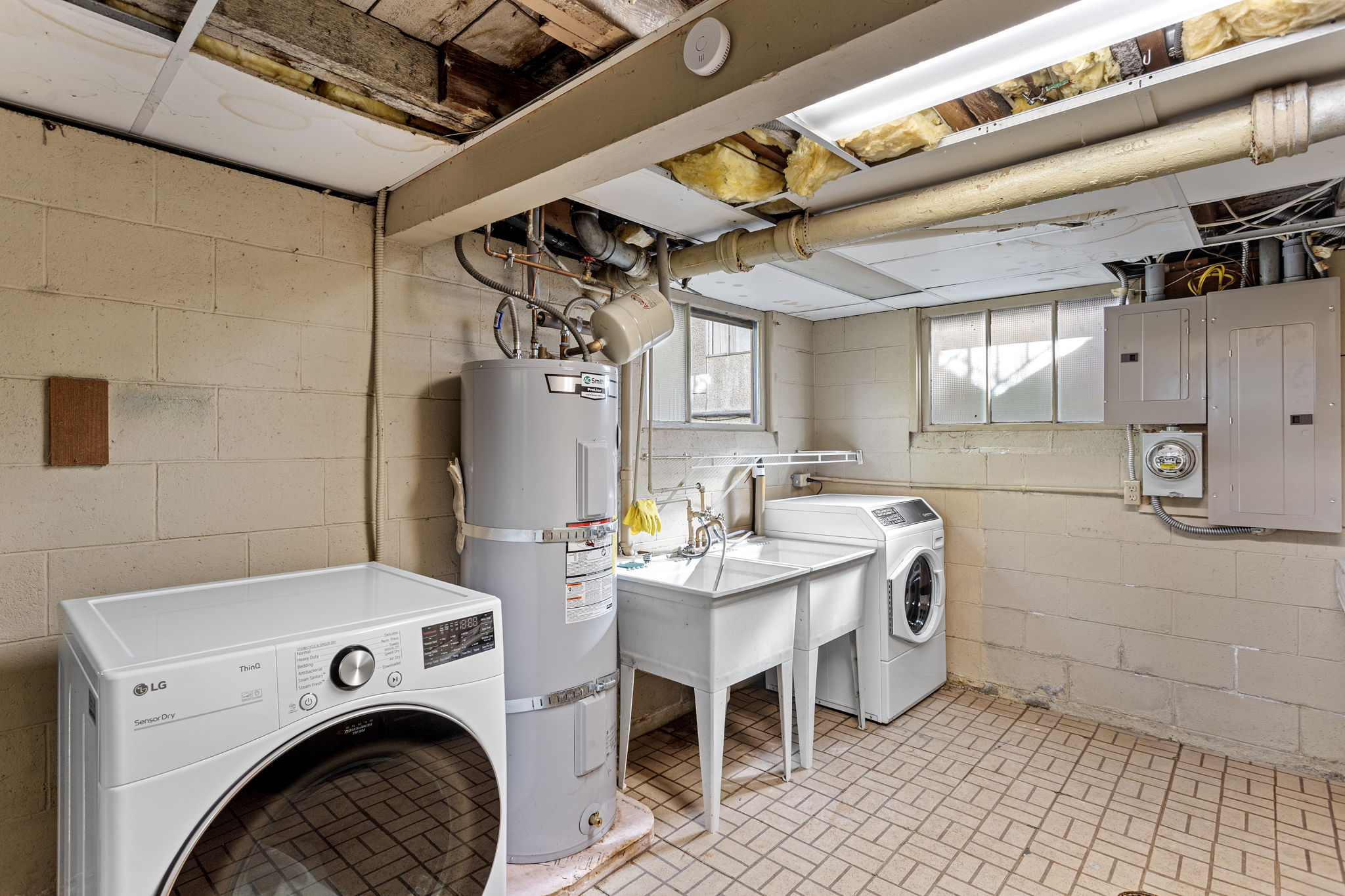 From the deck, step into a 370 sq ft partially finished laundry and utility room—complete with washer/dryer, deep utility sink, counter space for folding, and natural light. Quietly tucked away from the living areas, it keeps chores out of sight and sound.