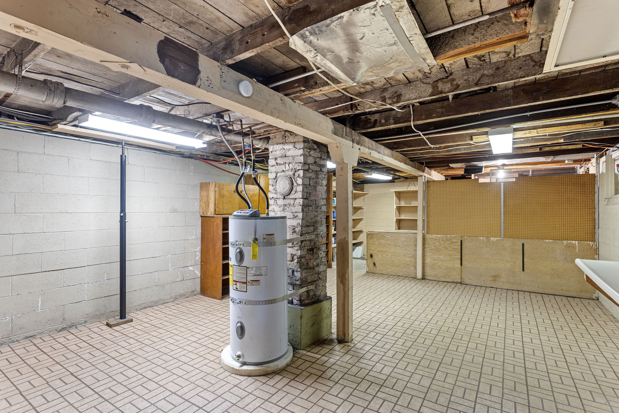 This expansive unfinished space includes a large workbench, pegboard wall, and built-in shelving—ideal for a home workshop, creative studio, or just everyday functionality. With around 1,000 sq ft total, there’s more than enough storage for two households.