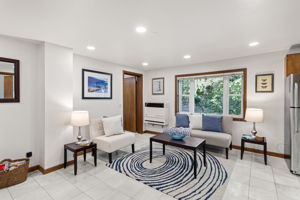 The main seating area is simple, cozy, and framed by greenery just outside—privacy and nature without giving up convenience.