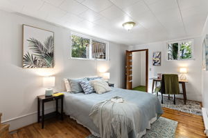 The spacious lower-level suite includes a walk-in closet, real hardwood floors, and windows that welcome west-facing light—ideal for rest, work, or retreat.