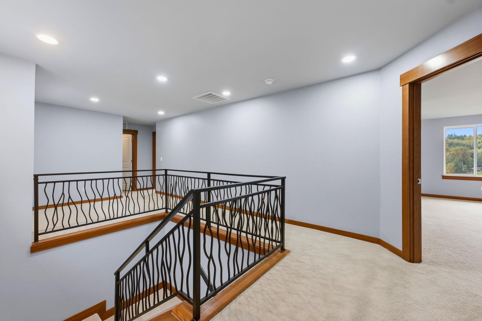 Top of stairs with small rec area to the left, bedroom 1 of 3 in the back