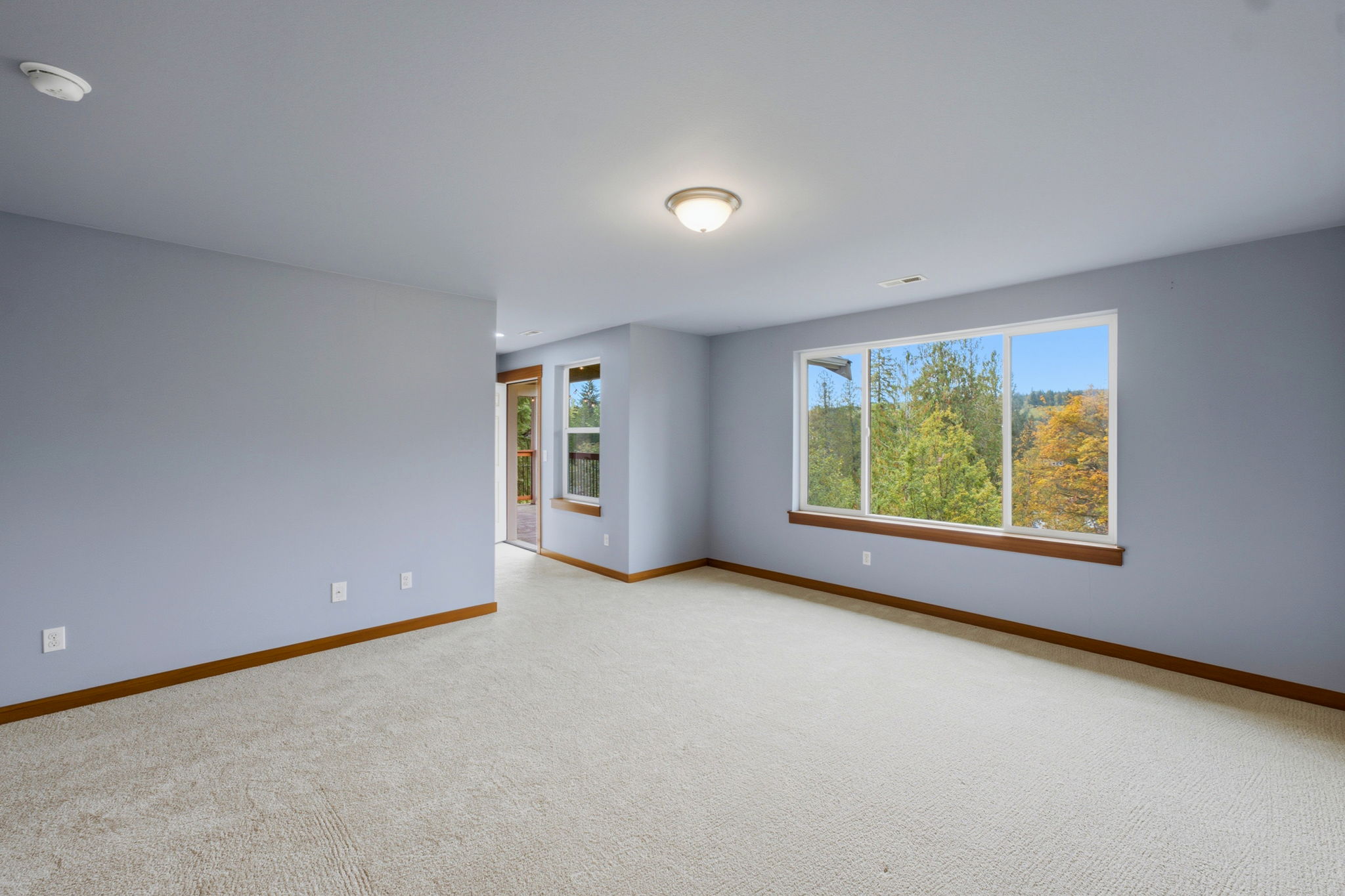 Upstairs primary bedroom passageway out to third level deck and continues to Primary bathroom and massive walk in closet