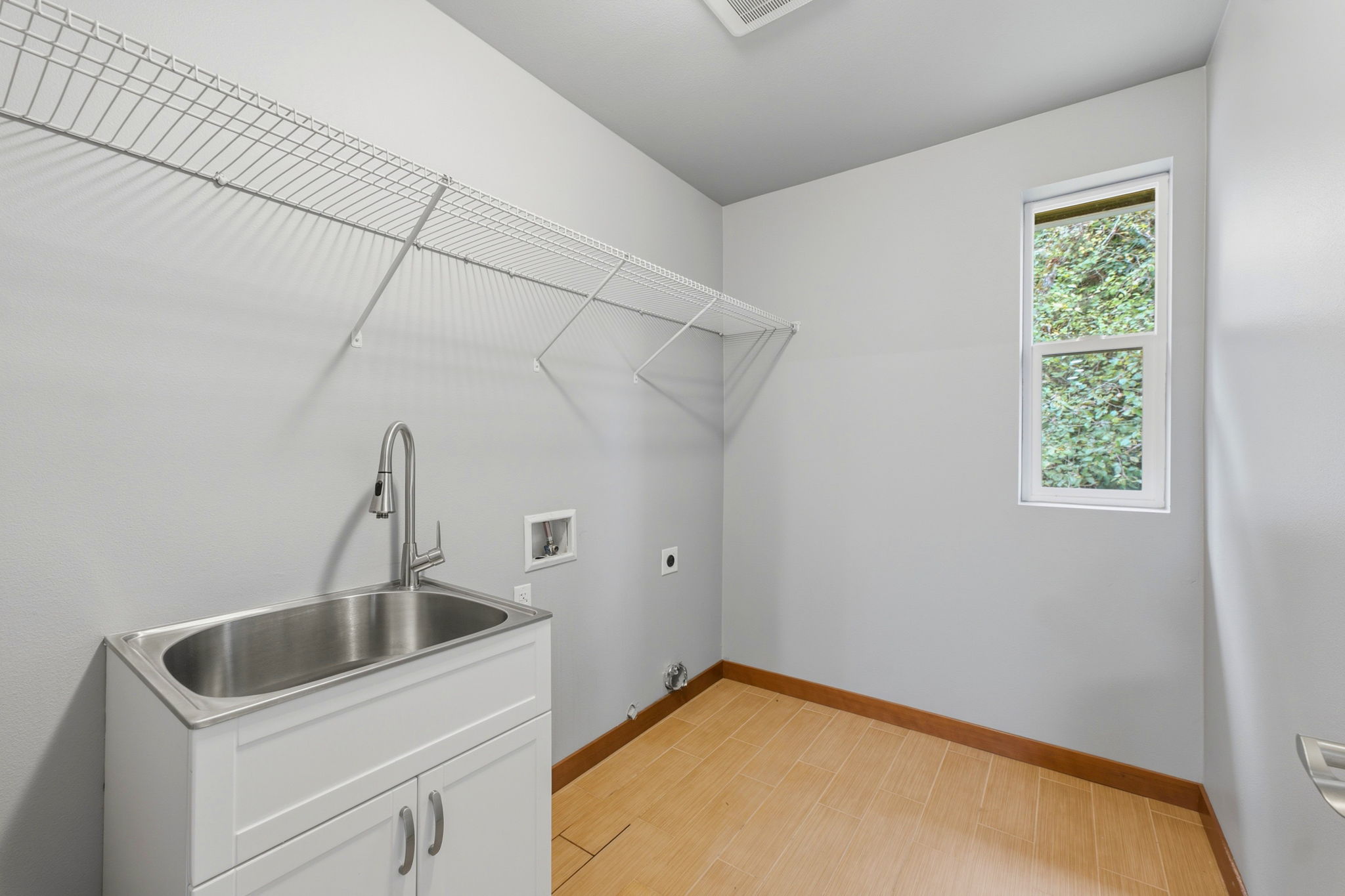 Upstairs laundry room with sink and extra storage