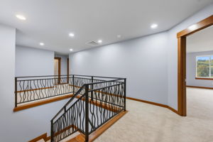 Top of stairs with small rec area to the left, bedroom 1 of 3 in the back