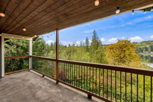 Upstairs primary bedroom deck overlooking the water and wooded views