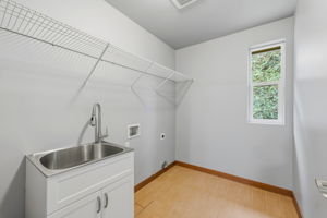 Upstairs laundry room with sink and extra storage