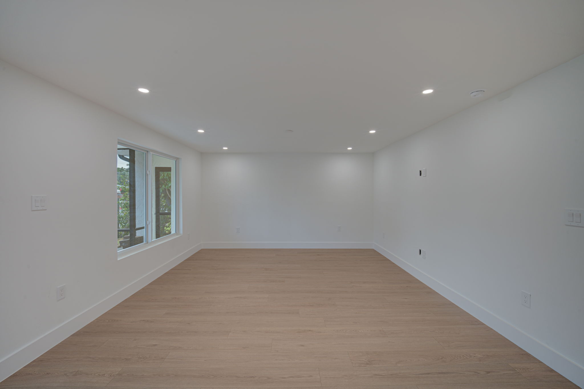 Open-concept living and dining area showcasing durable LVP flooring, neutral contemporary paint, and energy-efficient recessed LED lighting.