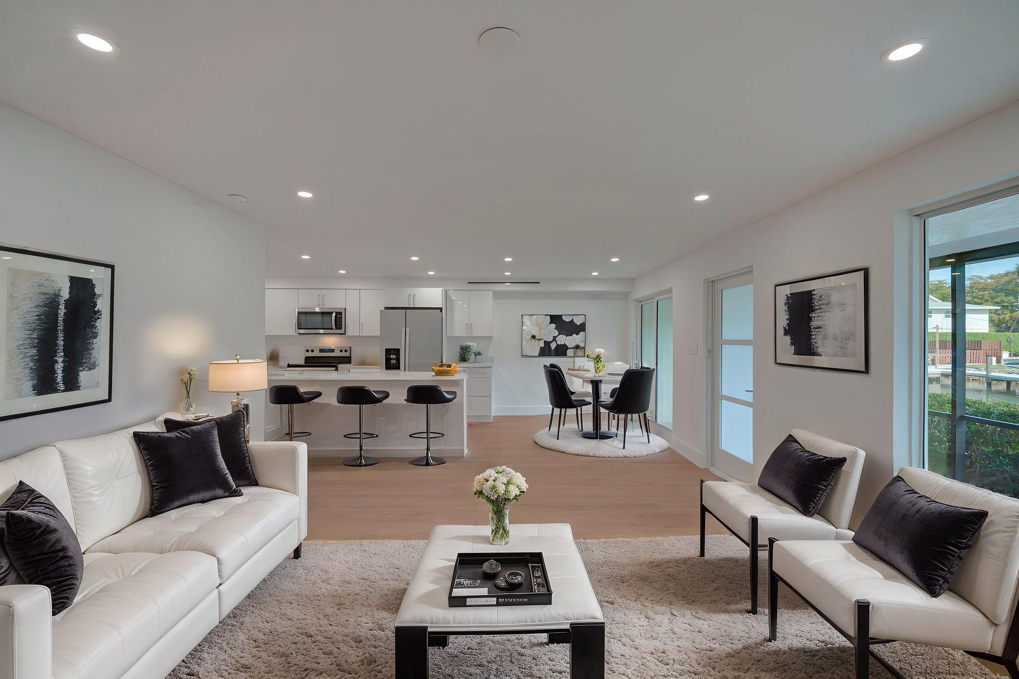 Virtually staged great room illustrating open-concept furniture placement, highlighting the flow between the dining area, living room, and outdoor lanai.