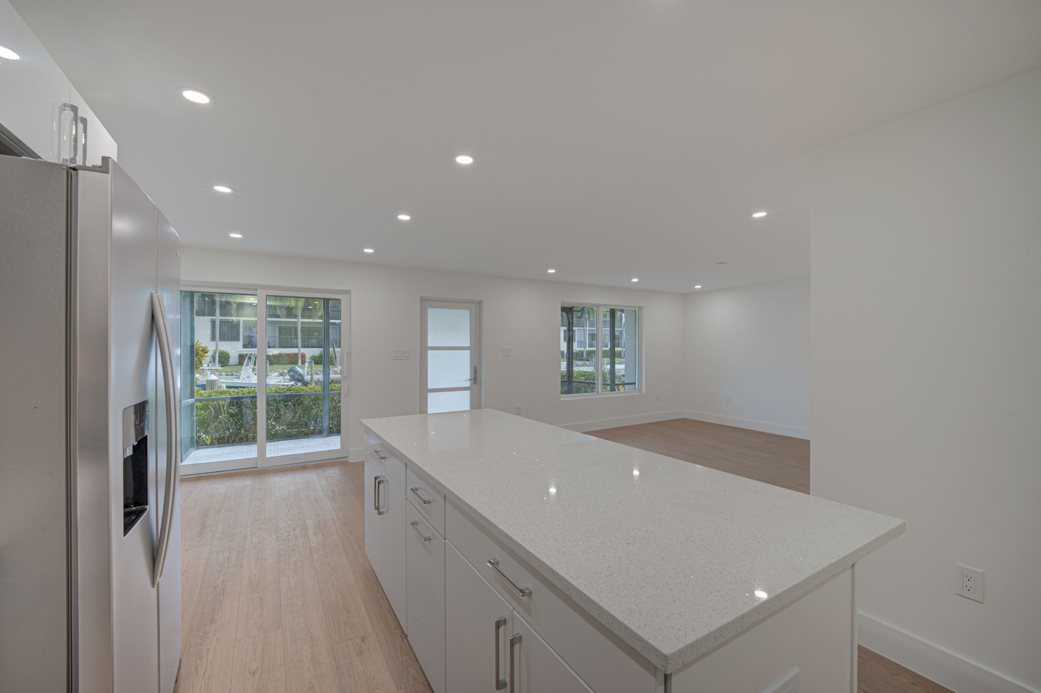 Reverse perspective from the kitchen looking outward, demonstrating the entertainer’s layout and direct line of sight to the waterfront.
