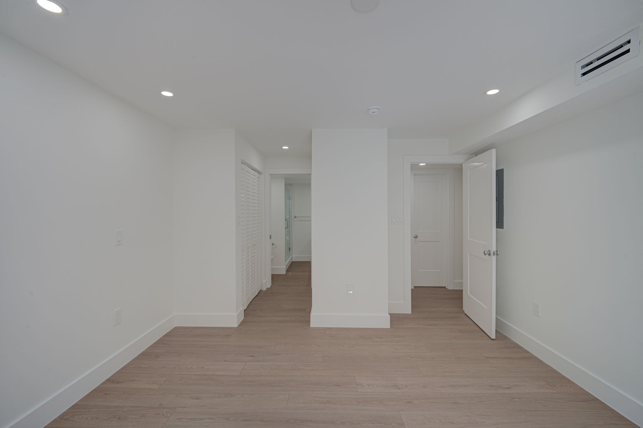 Secondary bedroom or flex space featuring a wide bi-fold closet, clean structural lines, and durable hard-surface flooring.