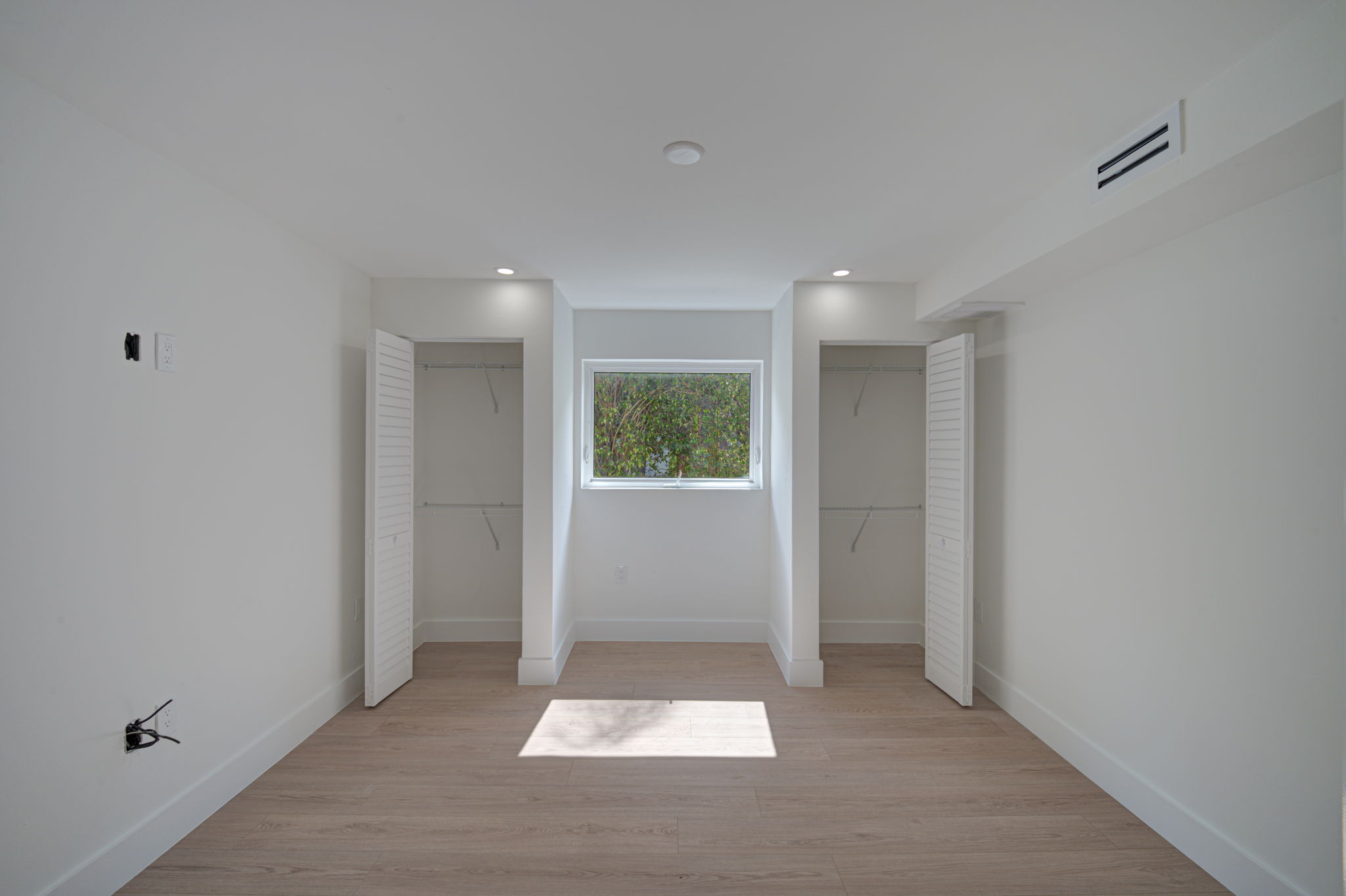 Bonus room or home office space featuring single-window natural light, continuous LVP flooring, and neutral color palette.