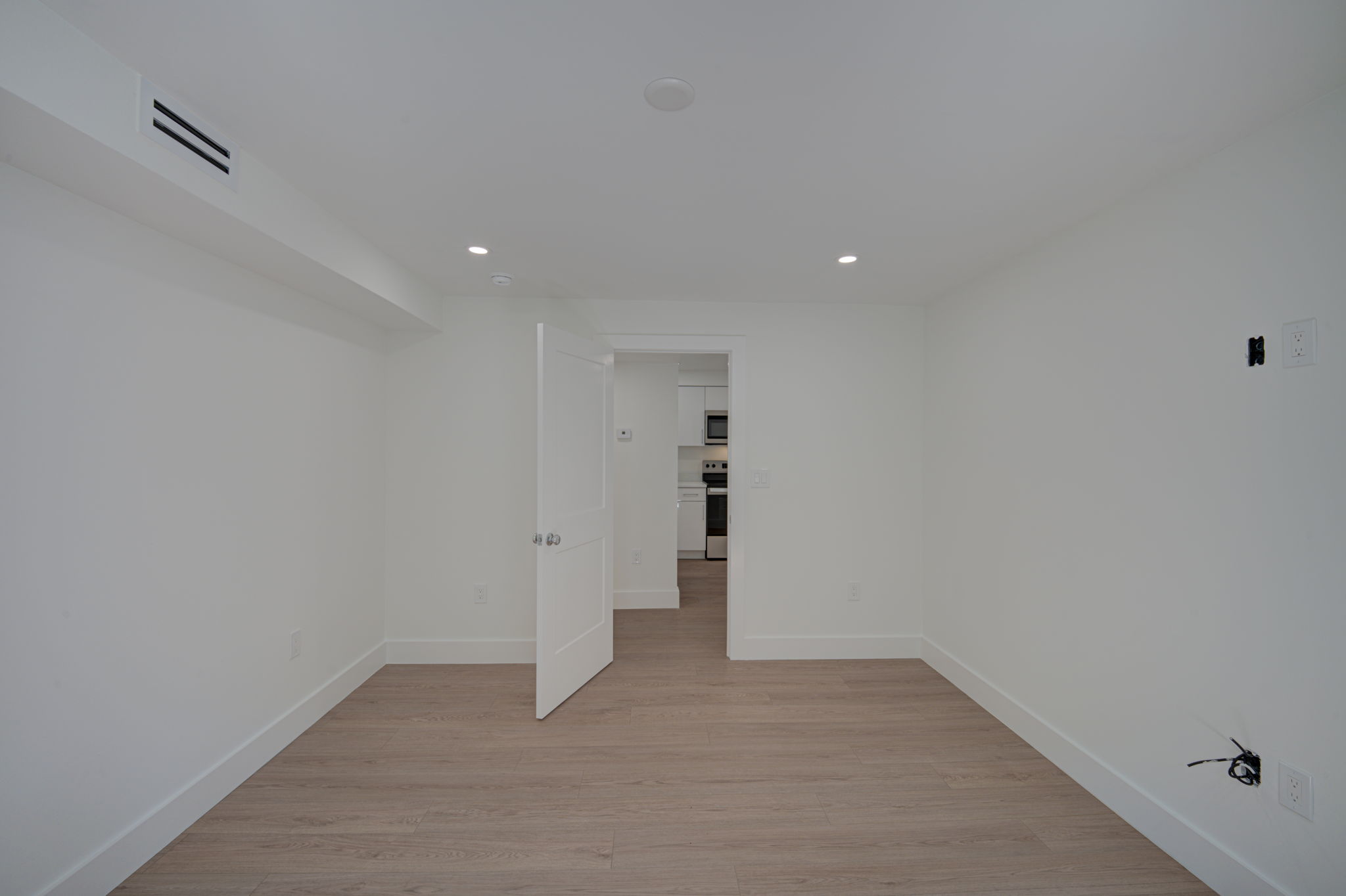 Interior hallway view detailing the consistent flow of luxury vinyl plank flooring and modern, flat-panel interior doors.
