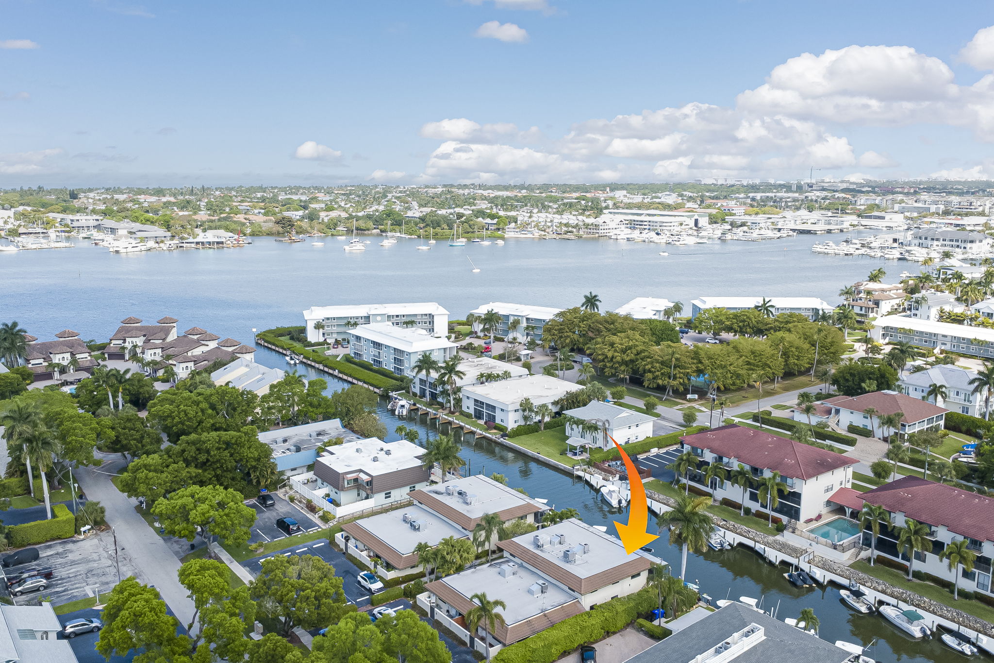 Wide aerial landscape with an indicator arrow showing the property's prime coastal location on the residential peninsula.
