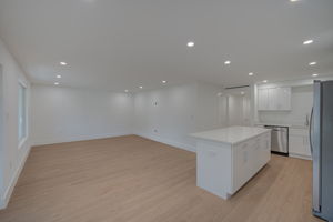Fully renovated chef’s kitchen featuring a large central island, premium quartz countertops, and custom white shaker-style cabinetry.