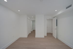 Secondary bedroom or flex space featuring a wide bi-fold closet, clean structural lines, and durable hard-surface flooring.