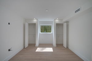 Bonus room or home office space featuring single-window natural light, continuous LVP flooring, and neutral color palette.