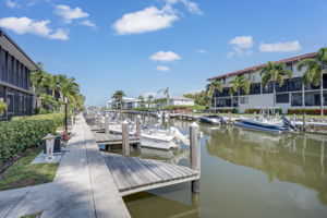 Rear exterior elevation of the residential building from the waterfront, highlighting the screened lanais and tropical landscaping.