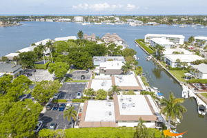 Mid-altitude aerial view detailing the complex's footprint, showing both the street-side entrance and the private waterfront backyard.