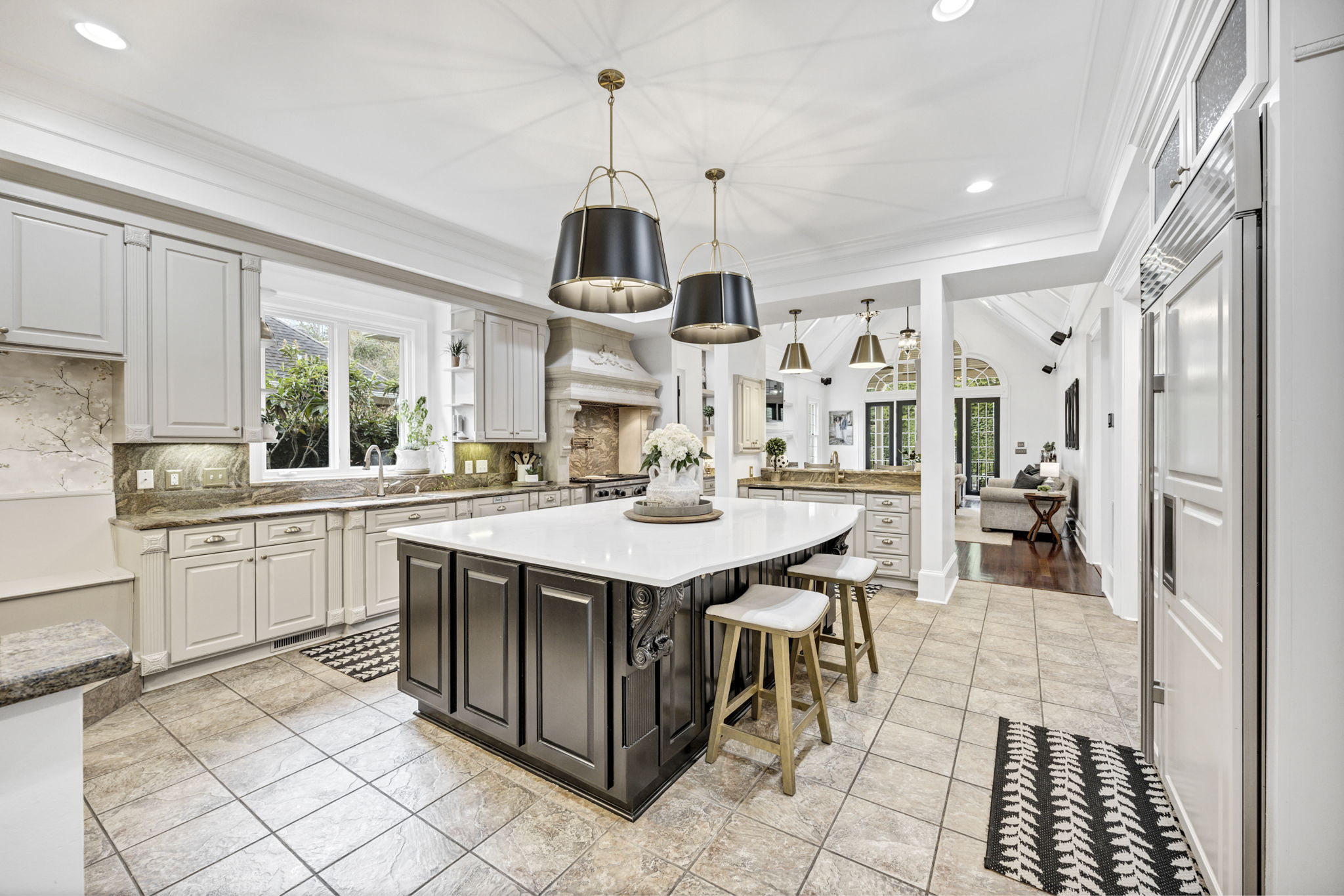 Bar area to the rear features under counter nugget ice maker, large sink with Delta bar faucet and side cabinetry for glass/beverage/coffee cup storage