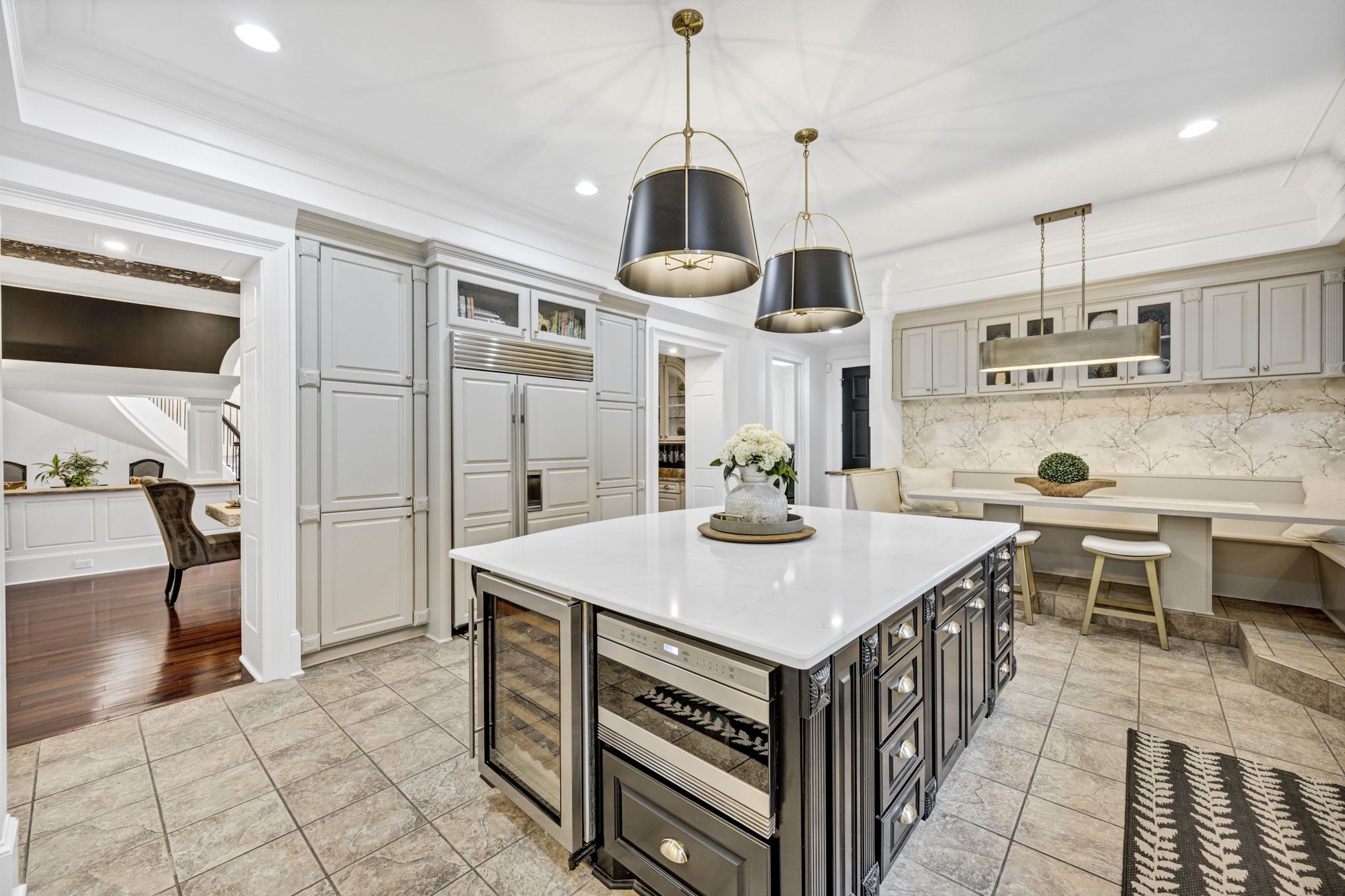 Sub-Zero Refrigerator and Freezer with custom paneling is flanked by deep pantry cabinets.  Sub-Zero, dual-zone wine refrigerator; Wolf drawer microwave