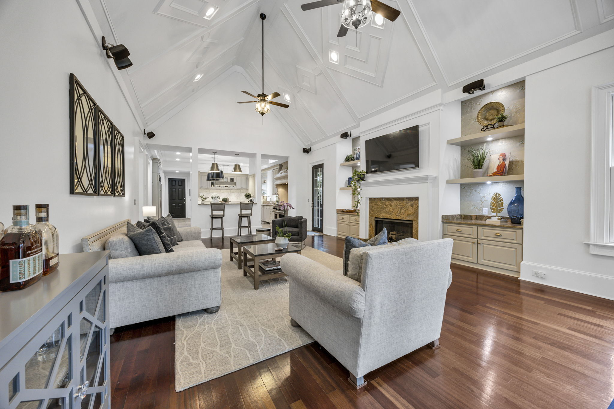 Gas fireplace flanked by new open shelves with lighting; cabinetry with granite countertops