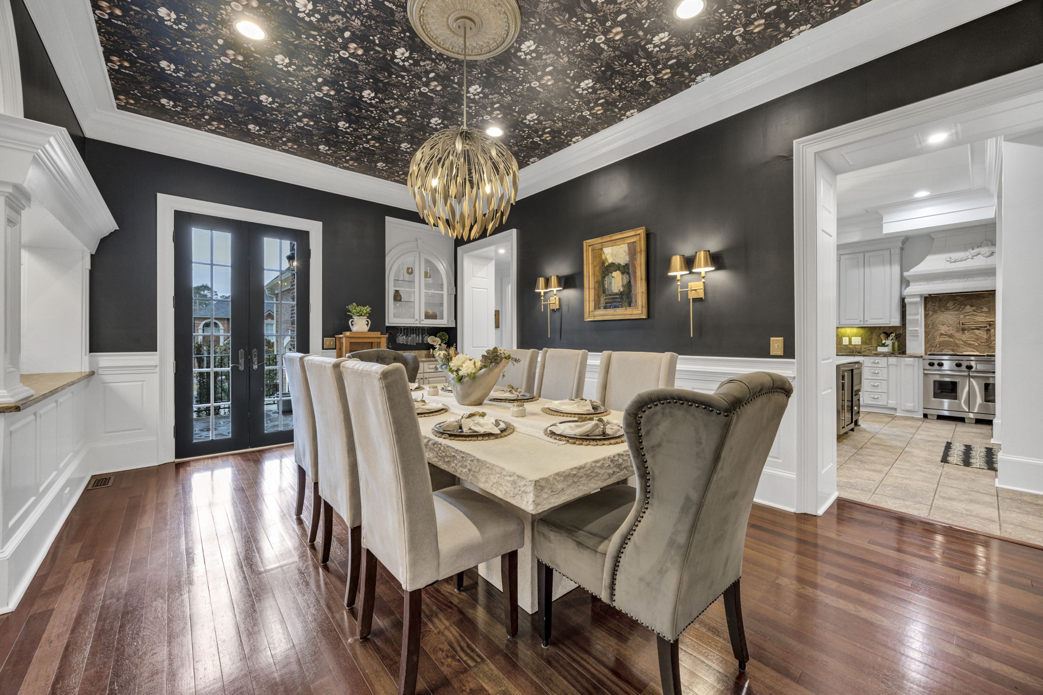 dining room with french doors leading to front patio; chandelier, wall sconces and recessed lighting