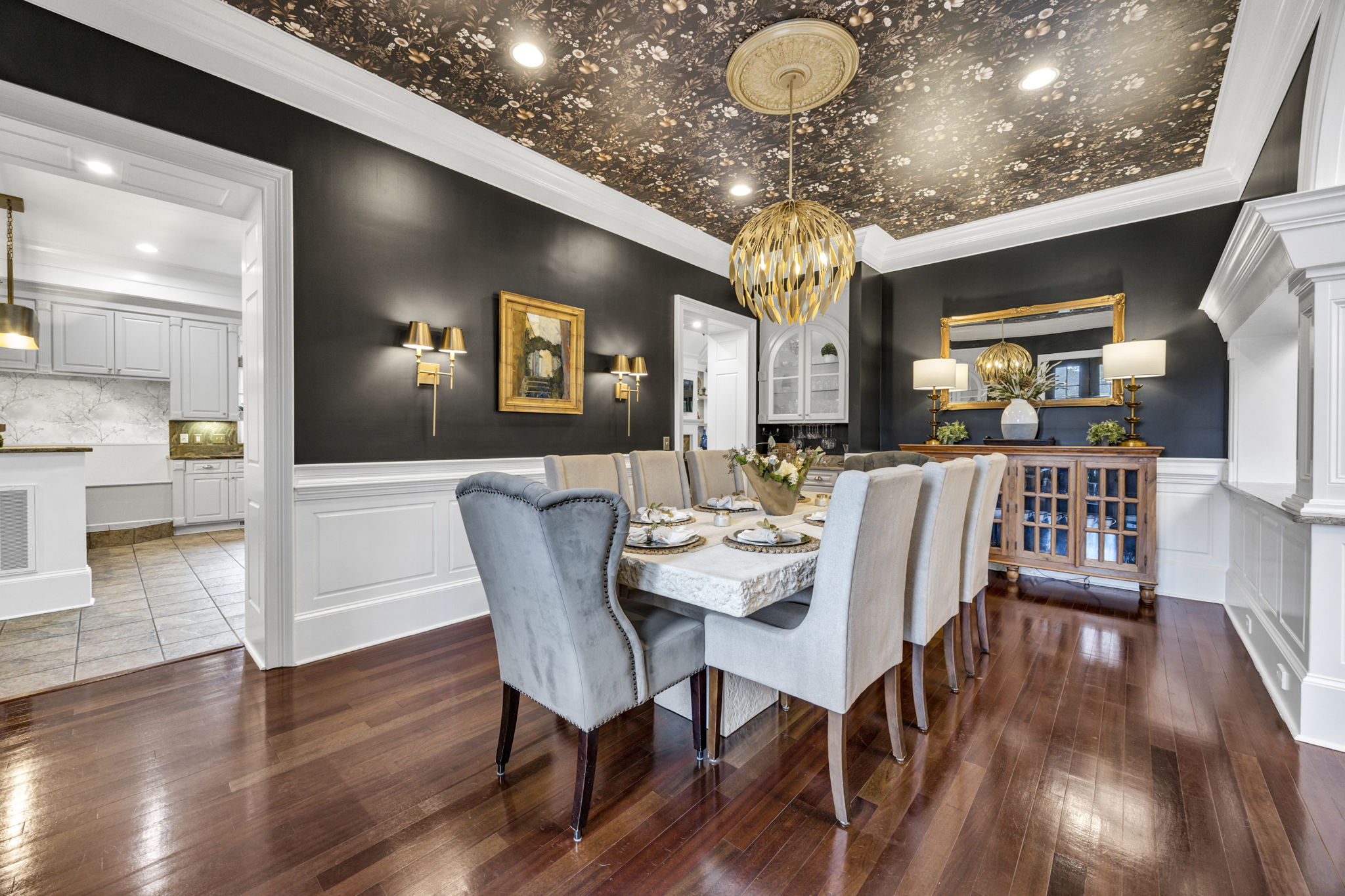 wall sconces; 2 openings to kitchen; dramatic wallpapered ceiling and champagne gold chandelier