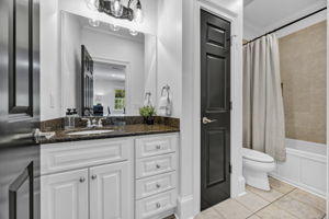 upstairs bedroom 1 ensuite bath with linen closet and tiled shower, granite counter