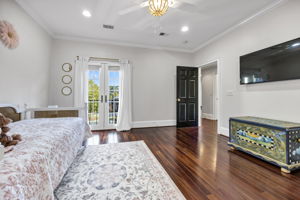 upstairs bedroom 4 with walk-in closet and french doors to juliet balcony overlooking courtyard driveway