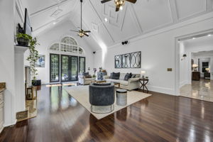 soaring, vaulted great room with stunning ceiling trim design; french doors exiting to back patio; marble corridor beyond