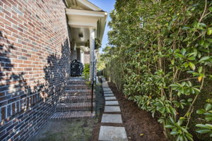 side porch and path leading to back garage door (w pet door) and small grassy area.  Also whole-house generator and 2 of 4 Bryant ACs on this side.