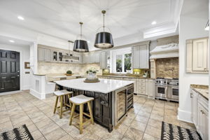 Oversized white quartz island is the focal point of this luxurious kitchen.