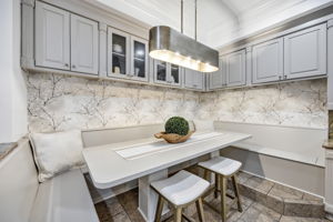 Cozy built-in breakfast nook features bench seating with storage and overhead cabinetry
