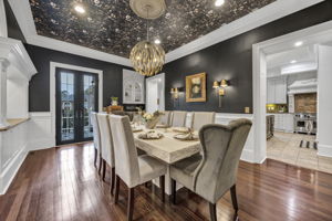 dining room with french doors leading to front patio; chandelier, wall sconces and recessed lighting