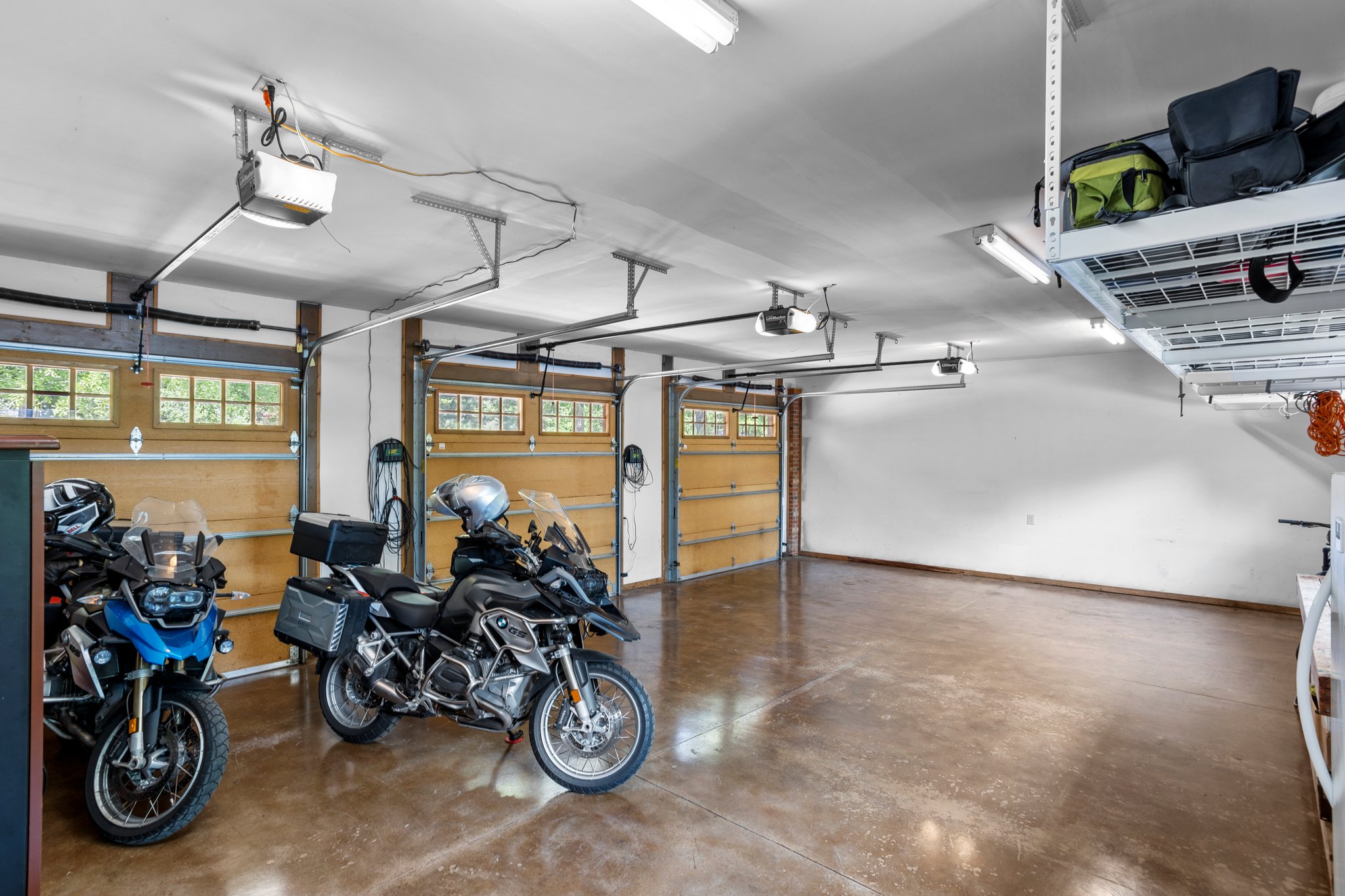 3 bay garage with polished concrete floors and industrial type shelving above.   Windows allow natural light to pour in while you're enjoying the space!