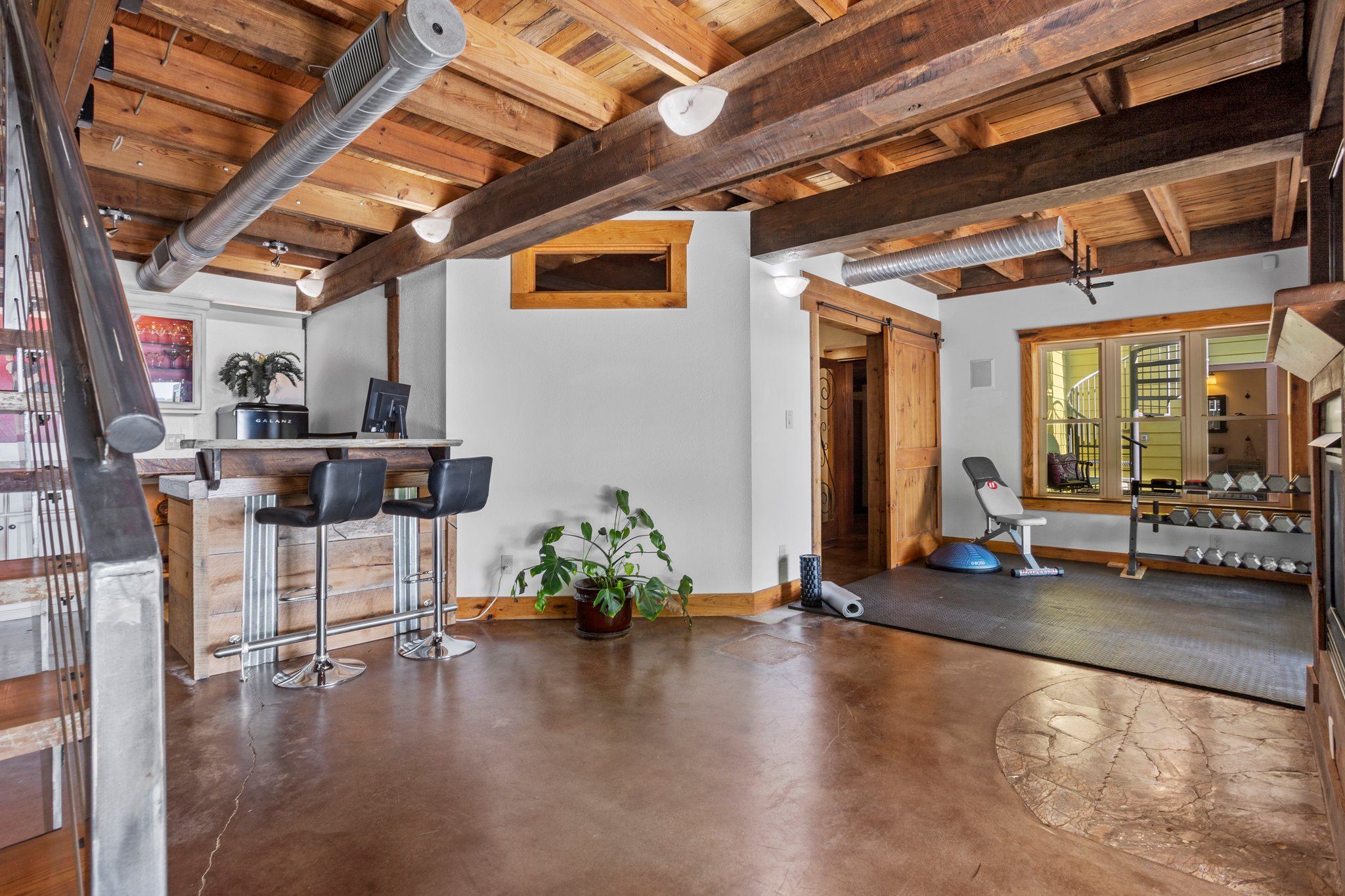 Lower level flex space.Leads out glass doors to covered porch, pool, outdoor kitchen and Guest Quarters!