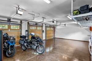 3 bay garage with polished concrete floors and industrial type shelving above.   Windows allow natural light to pour in while you're enjoying the space!