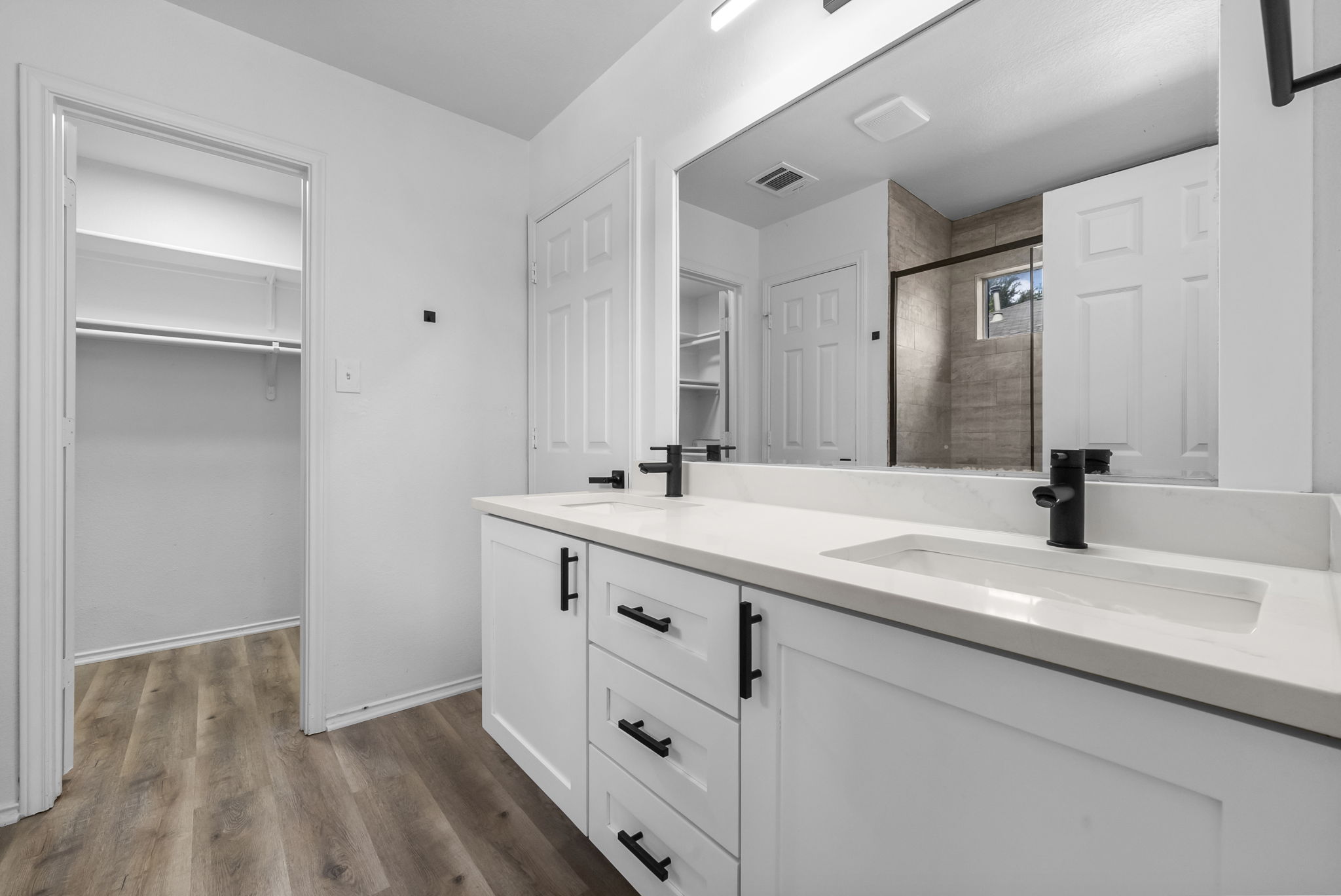 Primary bathroom on main level with double vanity, walk-in