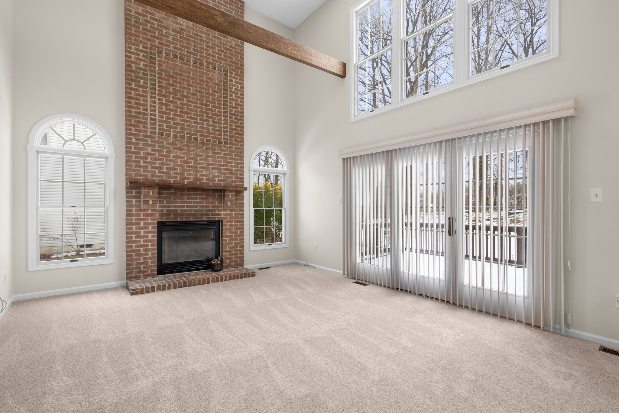 Family Room with Two Story Brick Fireplace and Exit to Rear Deck