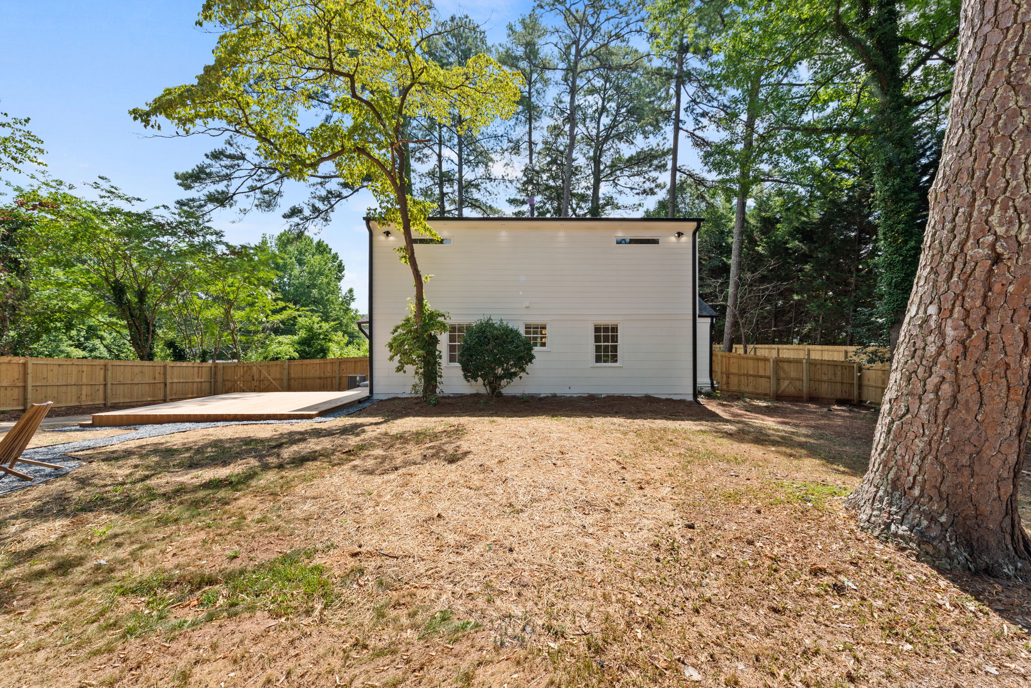 Backyard - The fenced backyard oasis featuring a fire pit and ambient soffit lighting is perfect for hosting gatherings or unwinding in serene comfort. With room for future enhancements such as a pool, this space offers boundless opportunities for outdoor enjoyment.